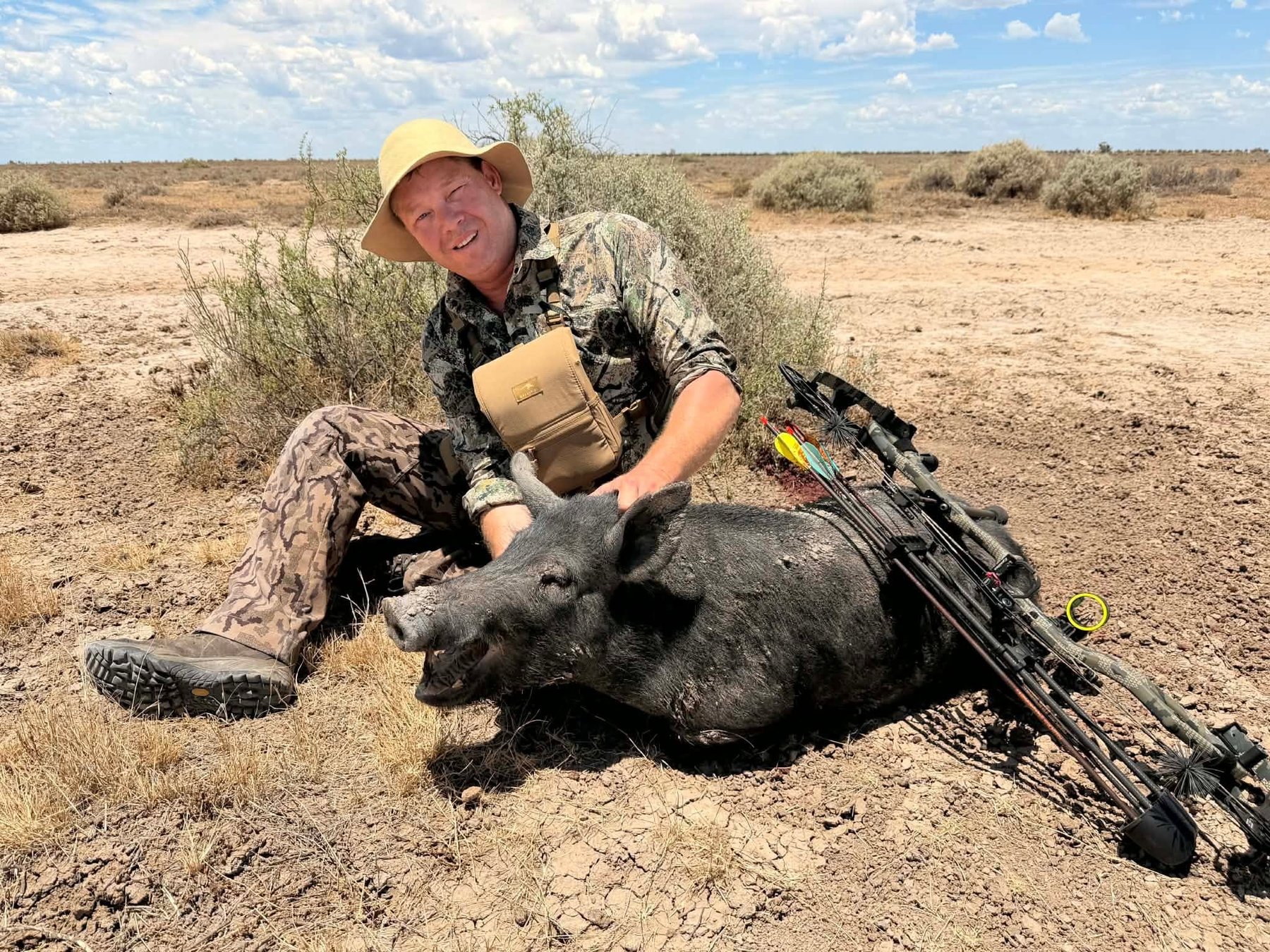 Hunter with a black boar taken in dry country