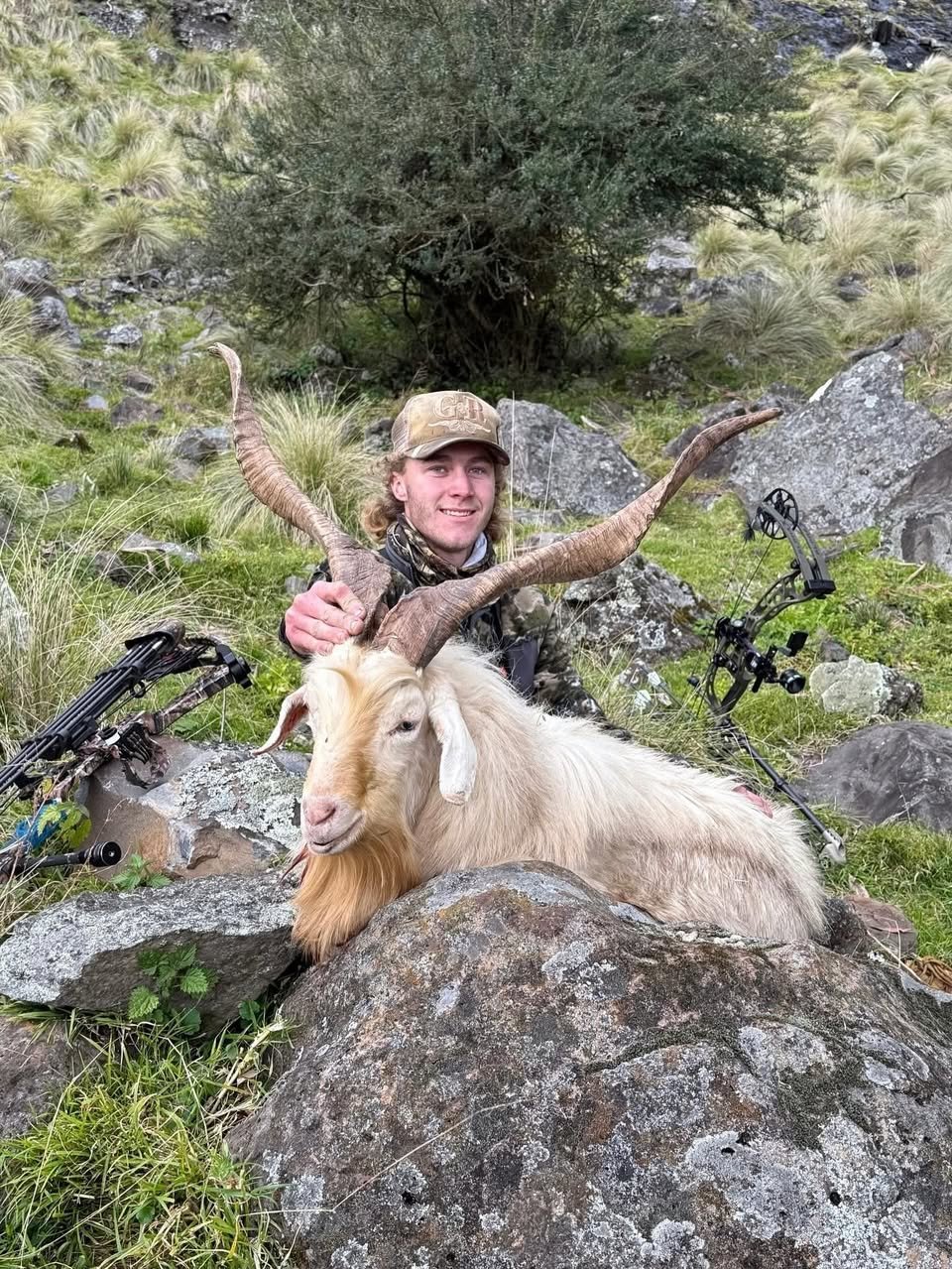 Hunter with a heavy-horned billy goat, red-fletched crossbow bolt in hand