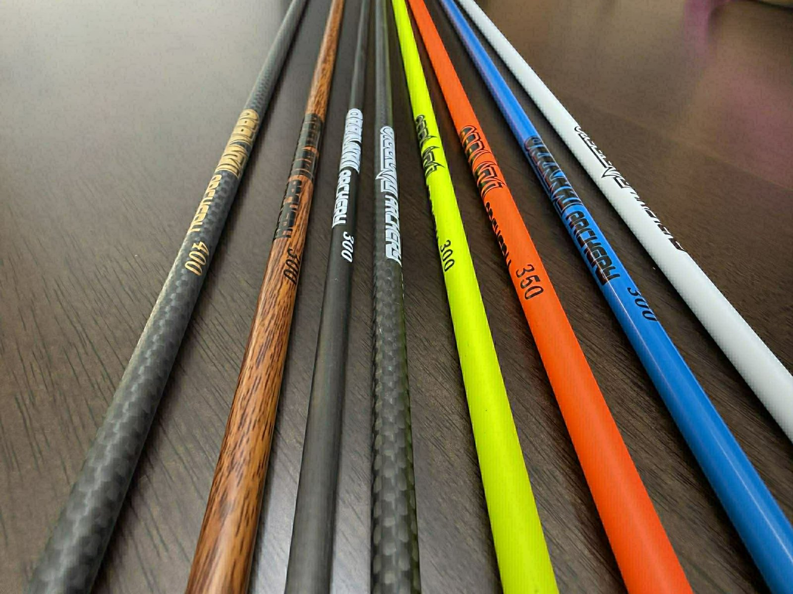 The full Orranni shaft family — 3K woven black, wood grain and the full color range side by side