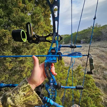 Bowhunter at full draw from a treestand